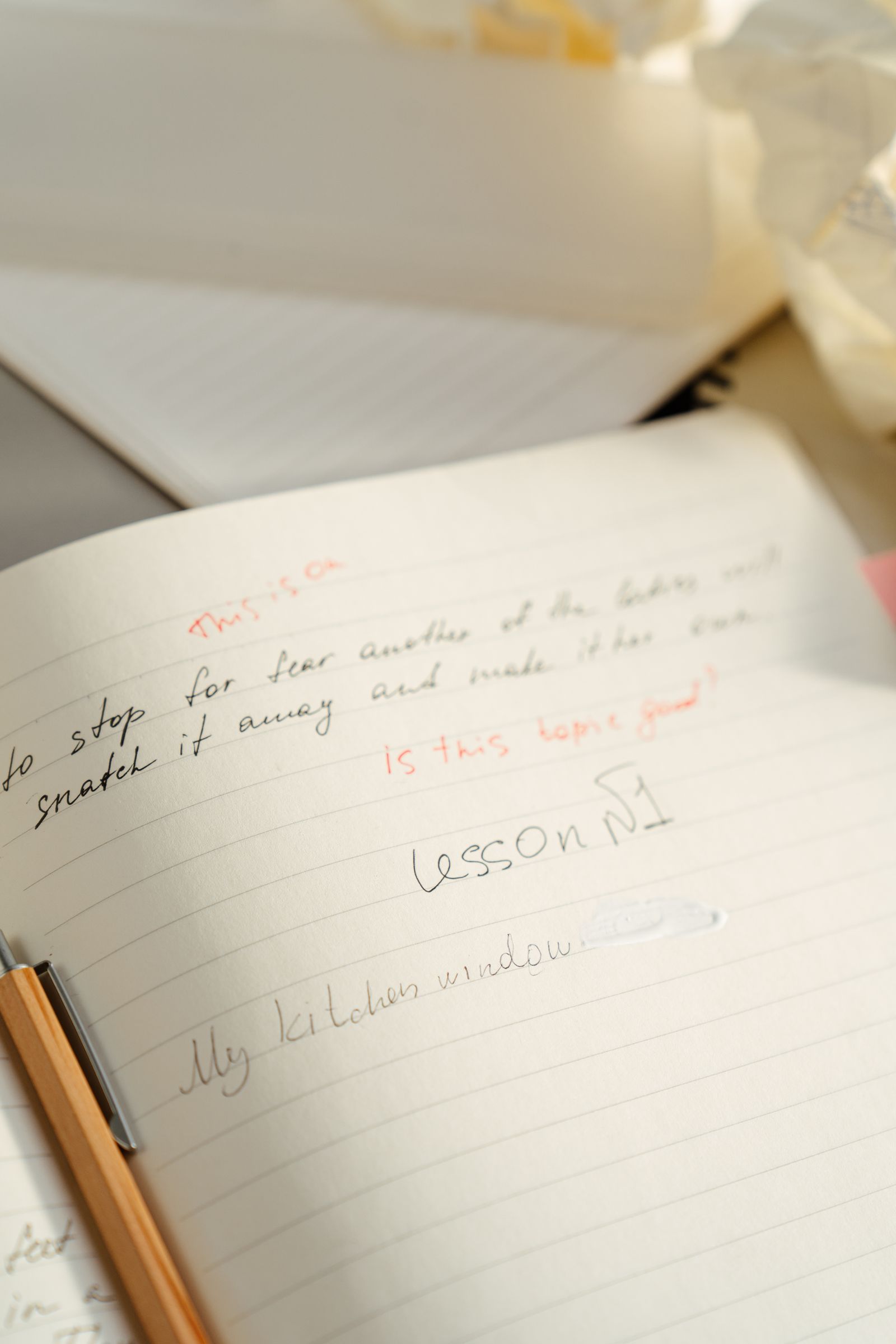 An open notebook filled with handwritten notes beside a pen